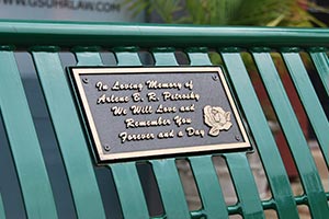 Bronze plaque with text and rose image on bench back
