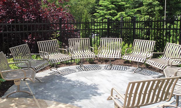 Custom Pullenium modular curved bench with arms in garden setting