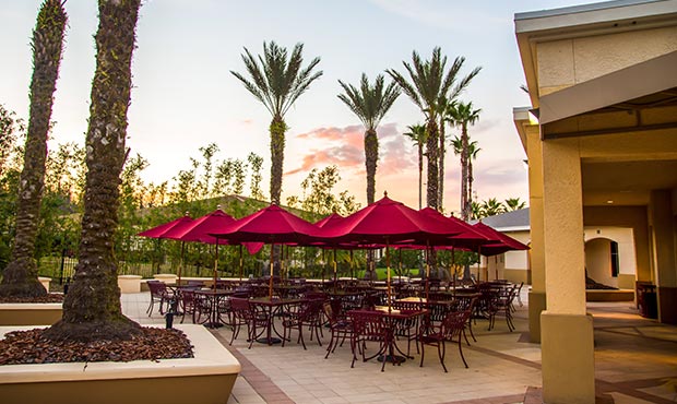 Courtyard Table and Chair sets with umbrellas at sunset