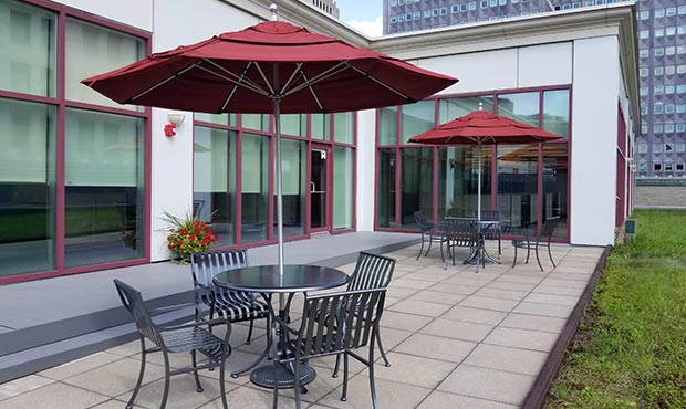 A pair of Courtyard table sets complete with umbrellas