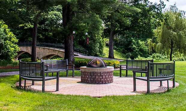 Four curved Reading Benches encircling a fire pit on campus