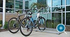 A pair of bicycles parked in an Exeter Bike Rack outside a YMCA