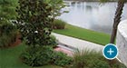 Sienna Bench with Back and plaque alongside a scenic pond path