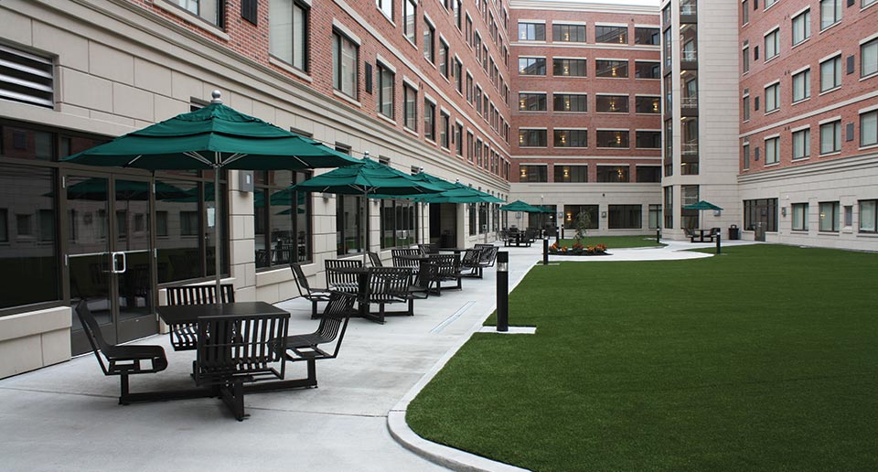 Hapsburg Table Sets with Umbrellas fill a courtyard with covered seating space