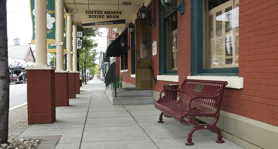 Lamplighter Bench with Back with Plaque in a main street setting